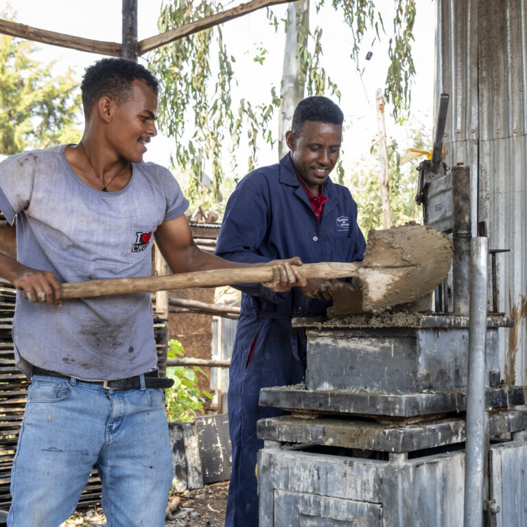 Zwei Männer produzieren Ziegelsteine.