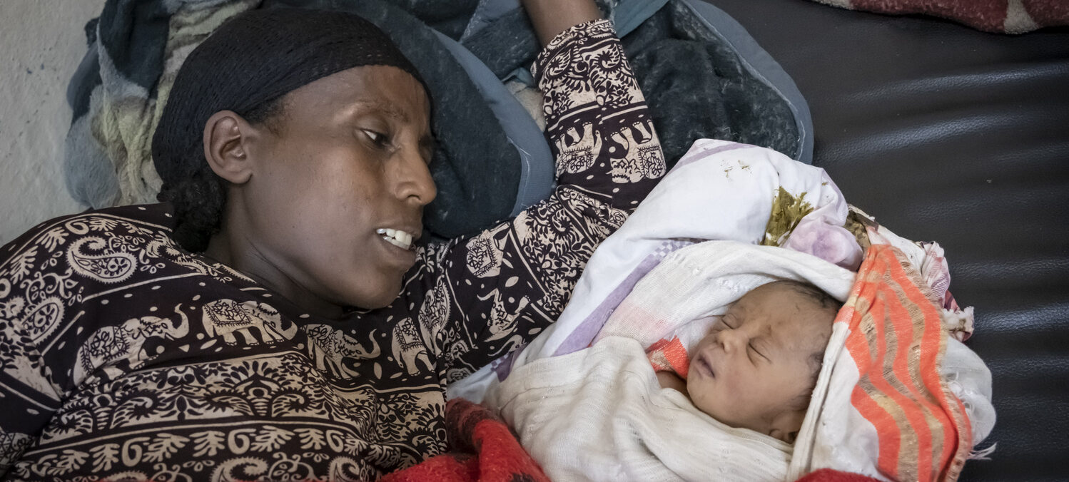 Kasach Tadesee begutachtet ihren neugeborenen Sohn. Er schläft.