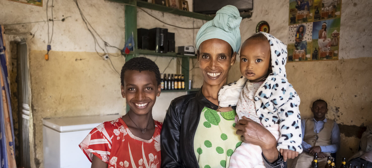 Almaz Getachew mit ihren beiden Kindern am lächeln.