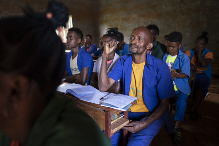 Adal Mune sitzt aufmerksam im Unterricht.