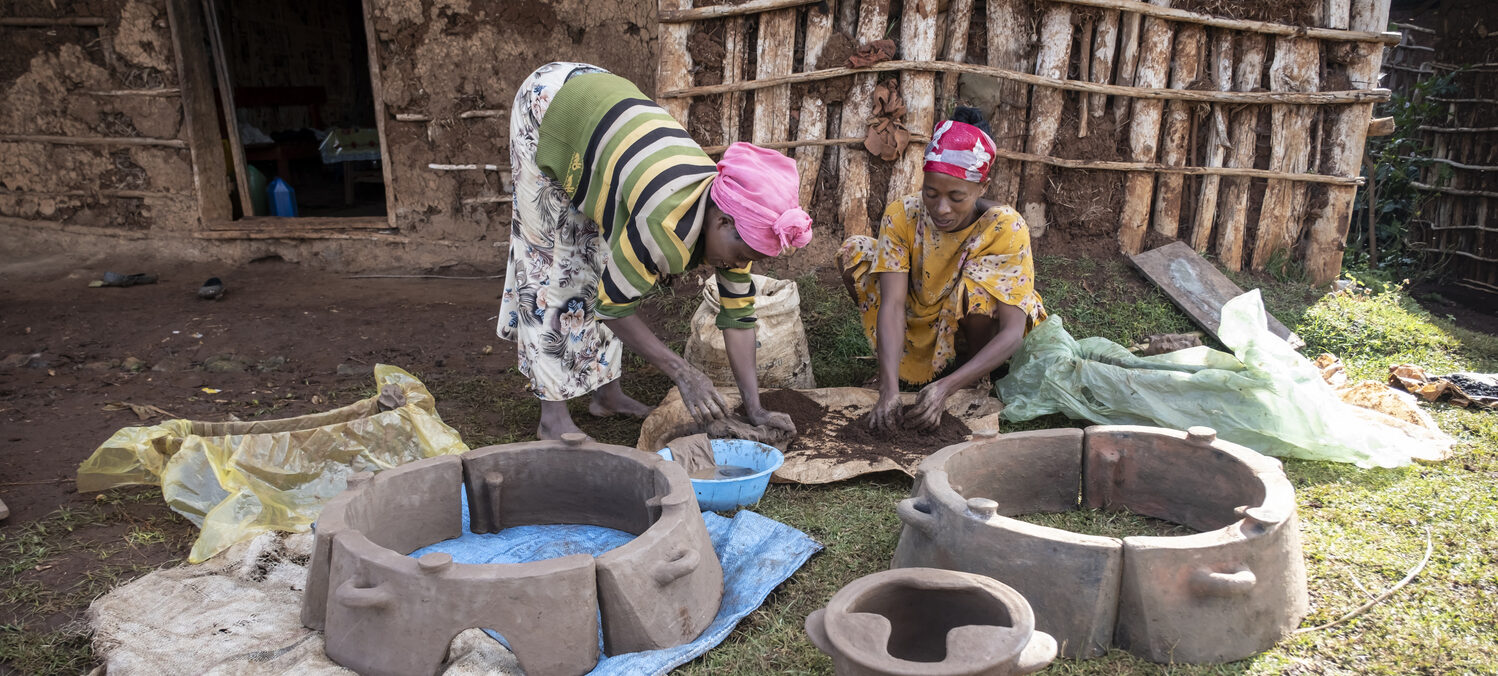 Zwei Frauen formen unter freiem Himmel Öfen aus Ton.