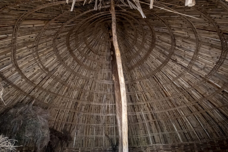 Innenansicht der Bäckerei Die Enat, Harar: rundes Strohdach, Holzbalken, zentraler Stützpfeiler sichtbar.