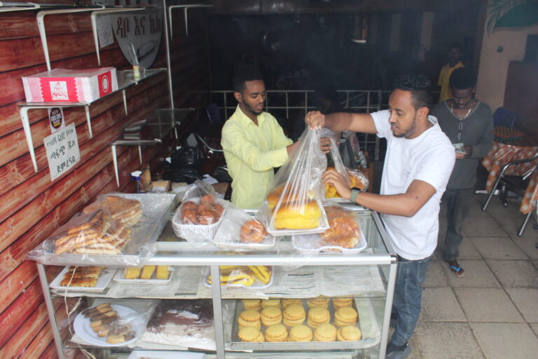 Zwei Männer verpacken Brot und andere Backwaren.