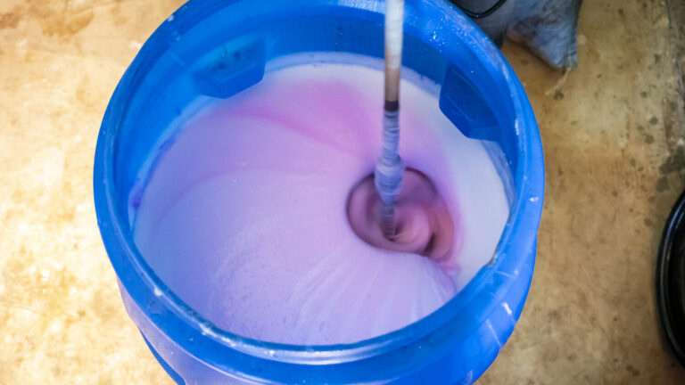 In einer großen blauen Tonne wird die Seife angemischt.