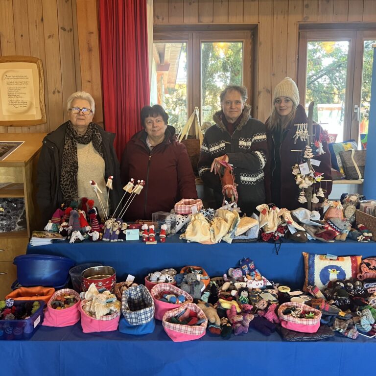 Ehrenamtliche verkaufen auf einem Adventsmarkt selbstgemachte Produkte.