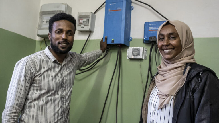 Ein junger Mann und eine junge Frau präsentieren eine Schaltanlage in der äthiopischen Energiebehörde.