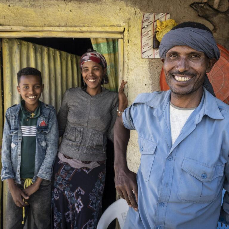 Ein Mann mit seiner Familie vor ihrem Haus.
