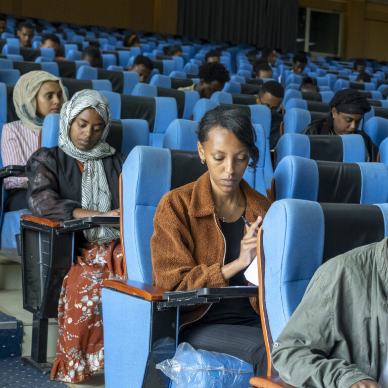 Junge Frauen und Männer beim Aufnahmetest für das ATTC in einem großen Hörsaal.