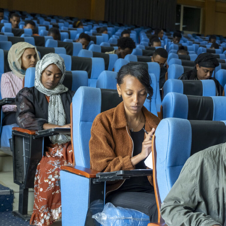 Junge Frauen und Männer beim Aufnahmetest für das ATTC in einem großen Hörsaal.