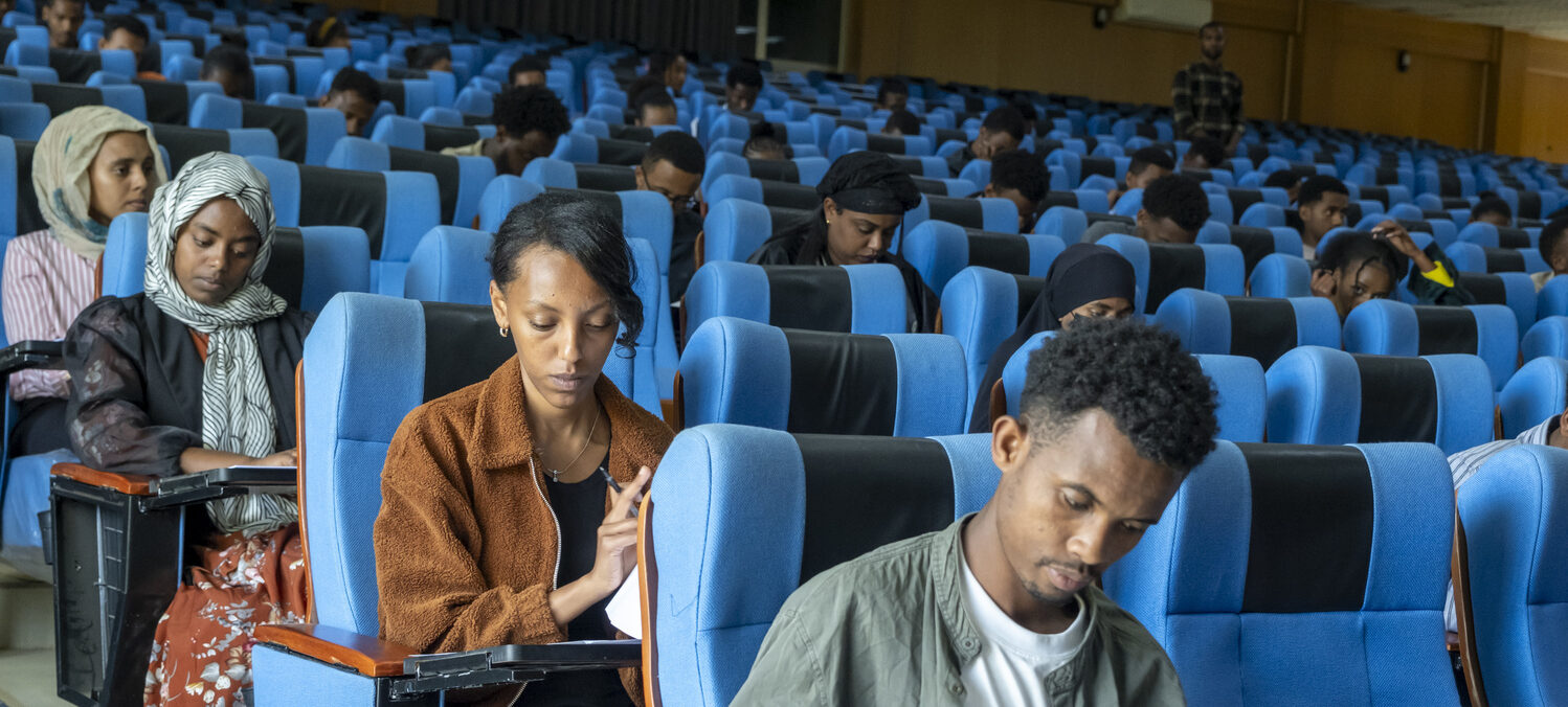 Junge Frauen und Männer beim Aufnahmetest für das ATTC in einem großen Hörsaal.