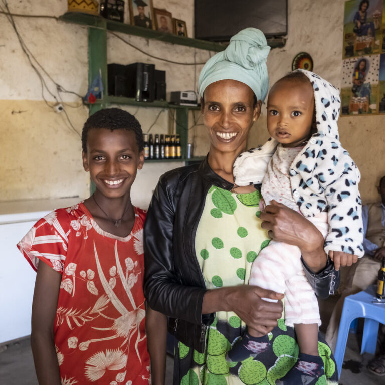 Almaz Getachew mit ihren beiden Kindern am lächeln.