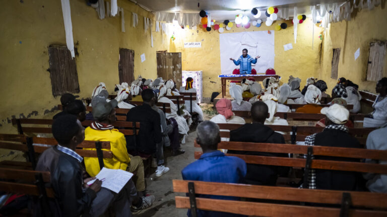Eine Gruppe von Menschen hört einem Vortrag zu.