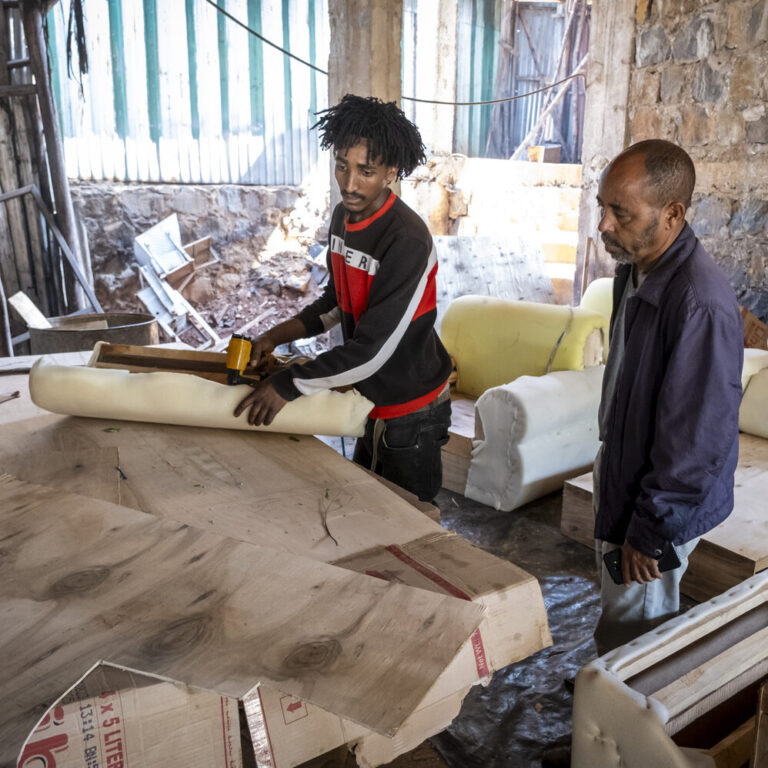 Zwei Männer arbeiten in einer Werkstatt.