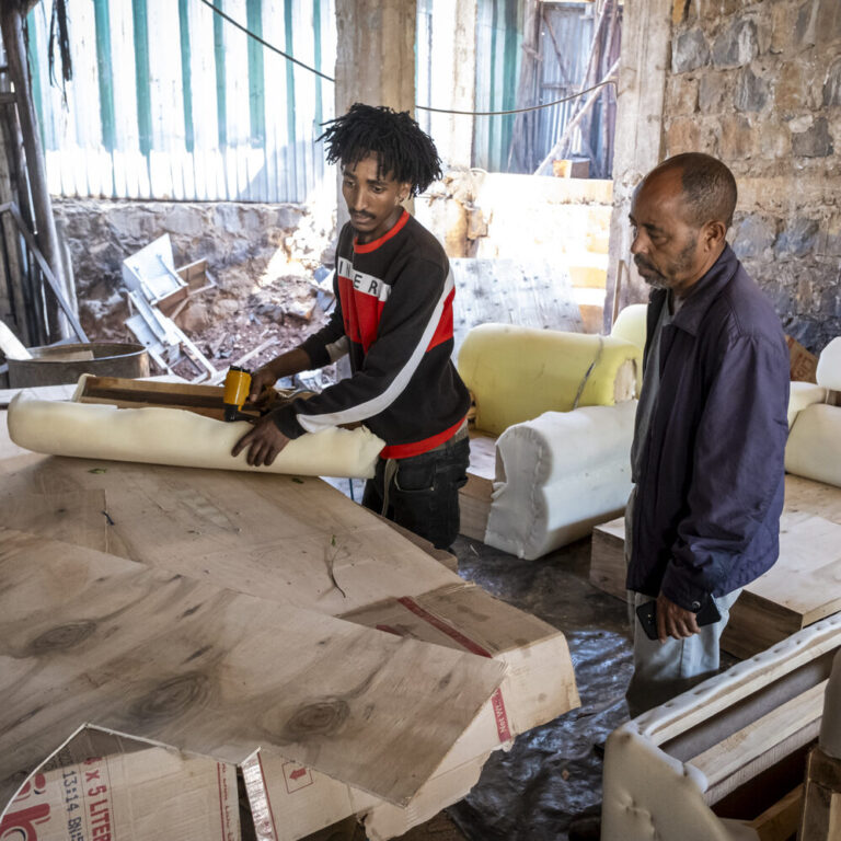 Zwei Männer arbeiten in einer Werkstatt.