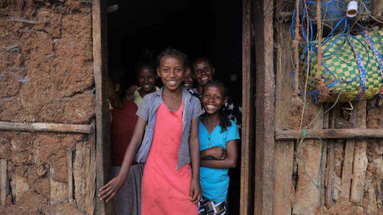 Mehrere Mädchen die lachend in einem Türrahmen stehen.