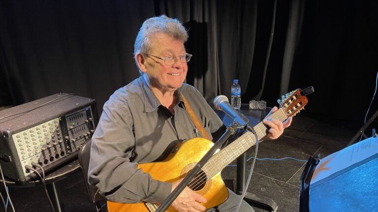 Der Musiker Klaus Grabenhorst mit seiner Gitarre auf der Bühne beim Benefizkonzert in Neuss.