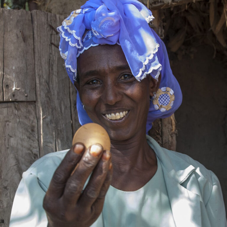 Eine Modellfarmerin mit einem Ei.