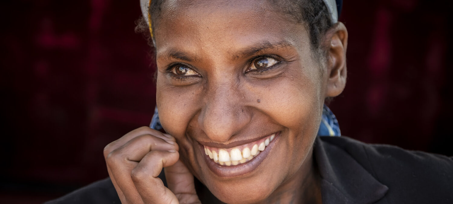 Eine Frau blickt lachend in die Kamera