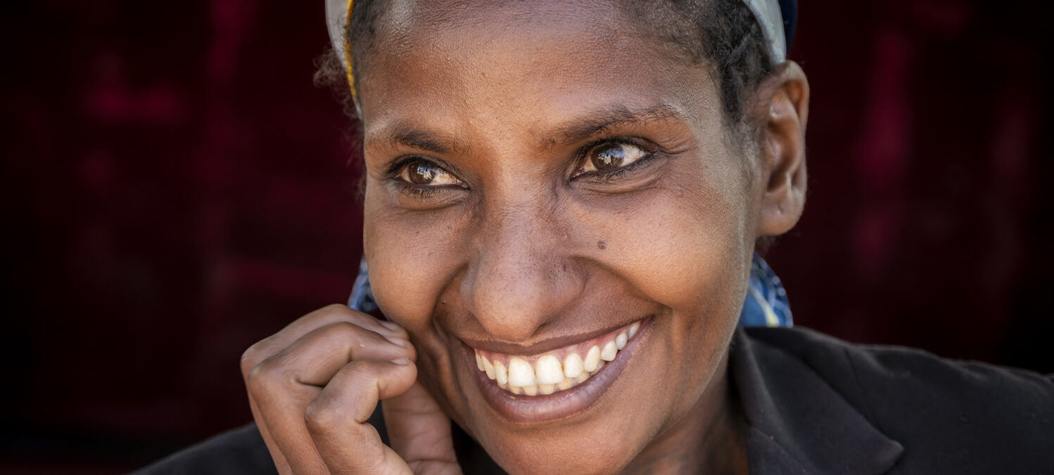 Eine Frau blickt lachend in die Kamera