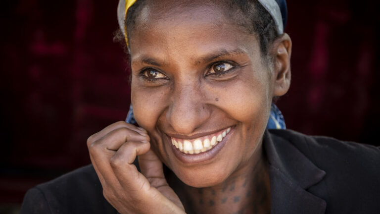 Eine Frau blickt lachend in die Kamera