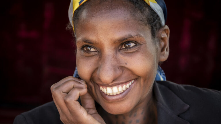 Eine Frau blickt lachend in die Kamera