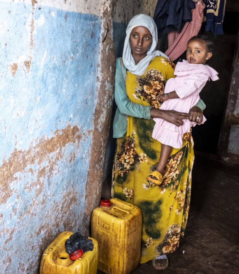 Eine junge Frau mit ihrer Tochter auf dem Arm.