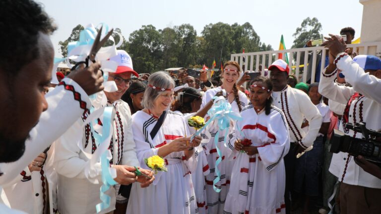 TVET Eröffnung. Man sieht Personen in weißem Gewand feiern.