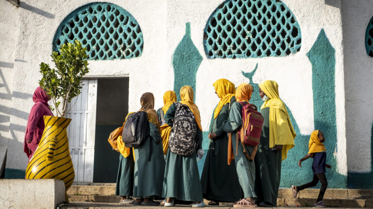 Eine Gruppe von Mädchen steht vor einer Moschee.