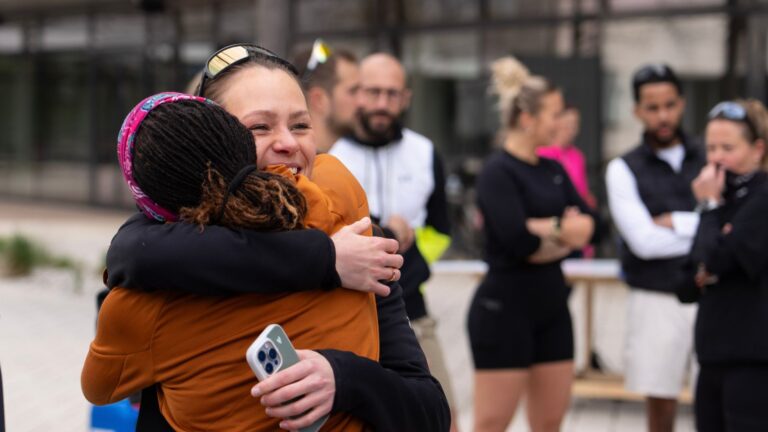 Zwei Frauen die sich bei einem Laufevent umarmen.