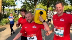 Männer, die mit einem Wasserkanister bei einem Lauf joggen.
