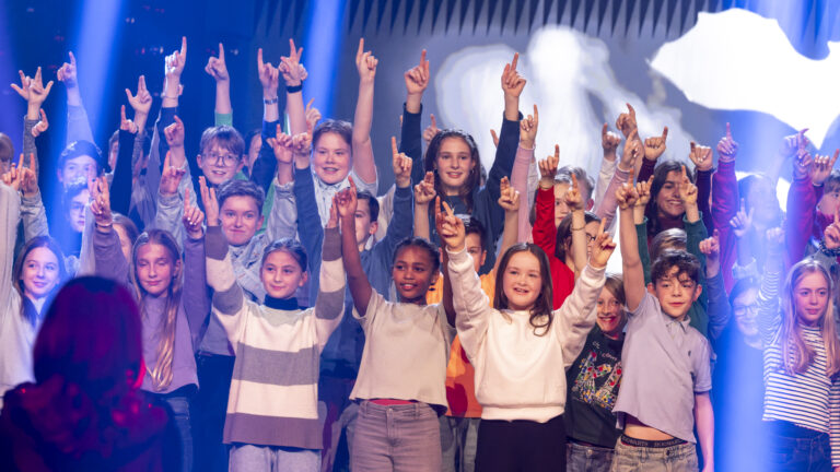 Kinder eines Chors halten ihre Hände in die Höhe