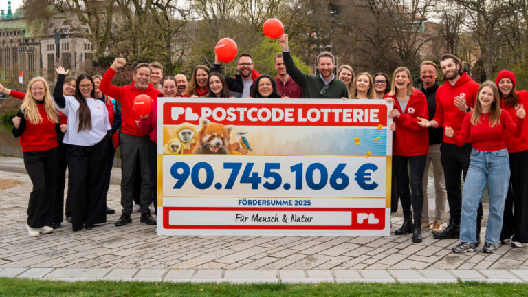 Mitarbeitende der Postcode Lotterie freuen sich, einen Spendenscheck zu überreichen