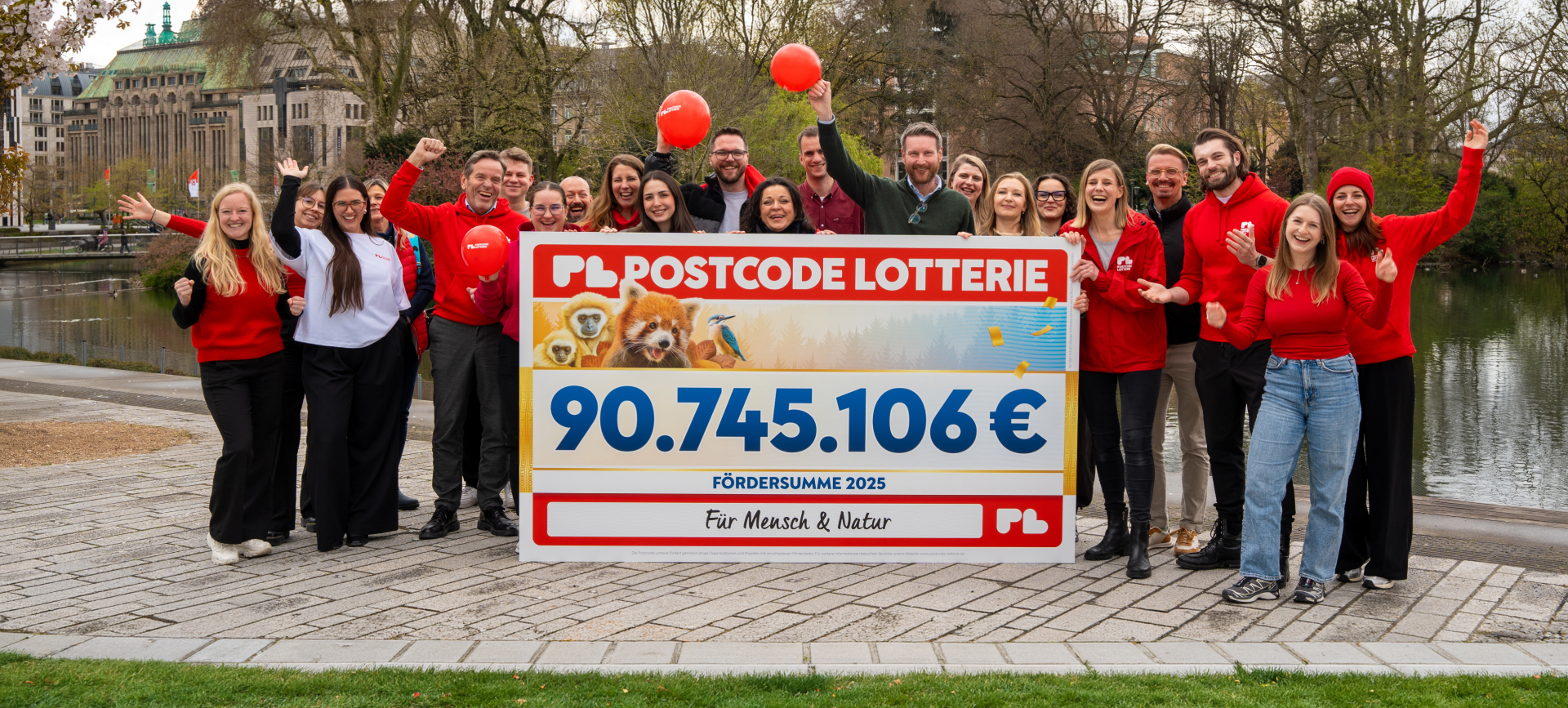Mitarbeitende der Postcode Lotterie freuen sich, einen Spendenscheck zu überreichen