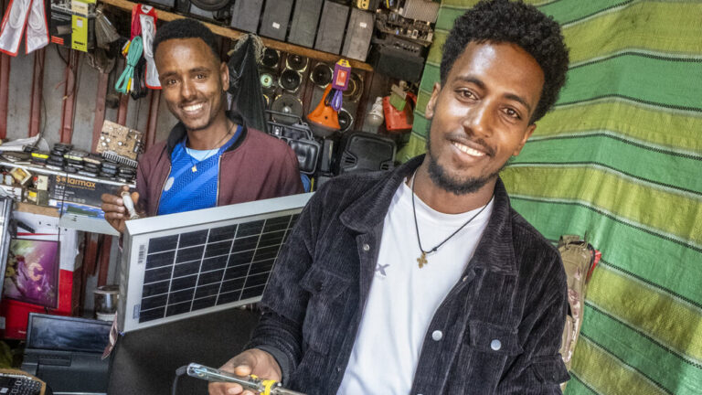 Zwei Männer die in einem Shop an einer Solaranlage arbeiten.