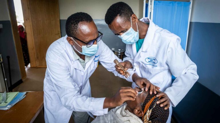 Projektgebiet Illu Gelan. Neues Gesundheitszentrum in Ijaji . Berhanu Leta, 34 (Brille, MfM-Kittel) ist Mitarbeiter in der Gesundheitsabteilung von Menschen für Menschen in Illu Gelan und im Gesundheitszentrum in Ijaji für die Augen-Untersuchung und Trachom-Operationen zuständig.
