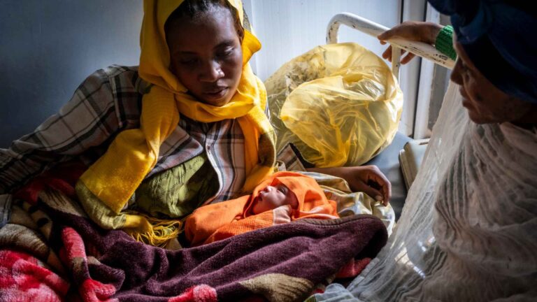 Projektgebiet Illu Gelan. Neues Gesundheitszentrum in Ijaji . Meskele Bacha, 18 (Mutter) hat im neuen Gesundheitszentrum in ihren ersten Sohn zur Welt gebracht. Tafeni Itansa, 43 (blaue Kopftuch) ist die Mutter von Meskele Bacha