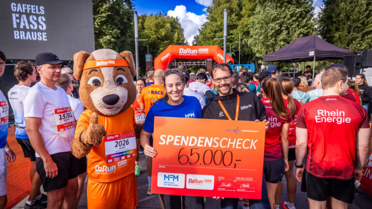 Überreichen des Spendenschecks in Höhe von 65.000€ mit MFM Mitarbeiter, B2Run Mitarbeiter und Maskottchen.