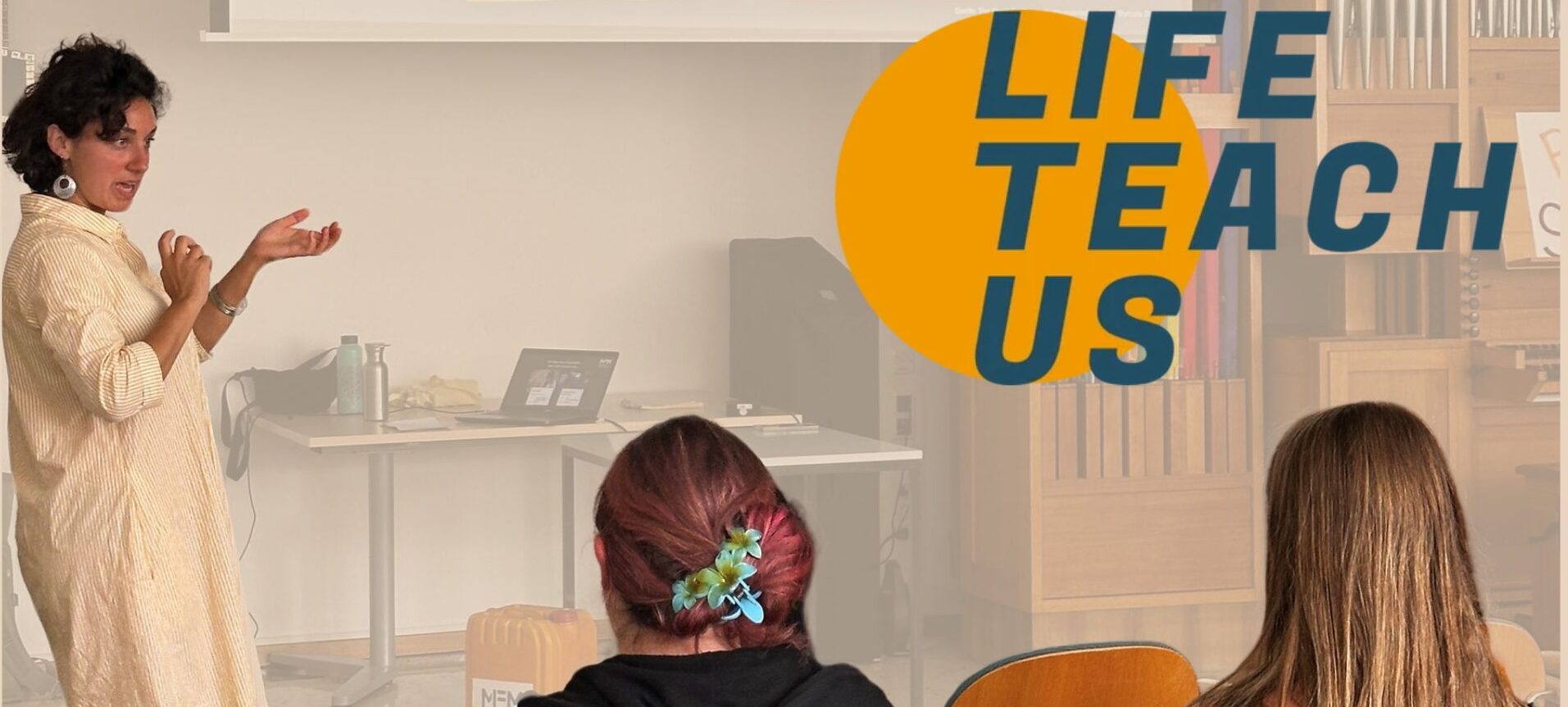 Ein Vortrag wird in einem Klassenzimmer gehalten, das LifeTeachUs Logo ist oben recht im Bild